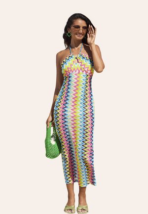 Multicolored zigzag patterned midi dress in lightweight fabric, featuring a halter neckline. Accessories include a green woven bag and sandals.