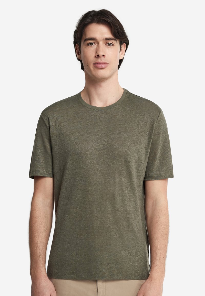 Olivgrön kortärmad T-shirt i mjukt, strukturerat tyg, med rund halsringning och avslappnad passform. Inga synliga logotyper.