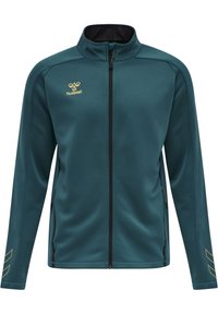 Teal zip-up jack met een zwarte binnenkraag, gouden logo en zijzakken met rits. Kenmerkend zijn de schuine gouden strepen op de mouwen.