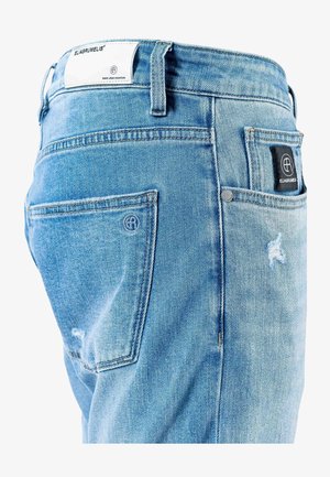 Lichtblauwe spijkerbroek met een vervaagde textuur, voorzien van een achterzak met een zwart label en logo, en verweerd detail in de stof.