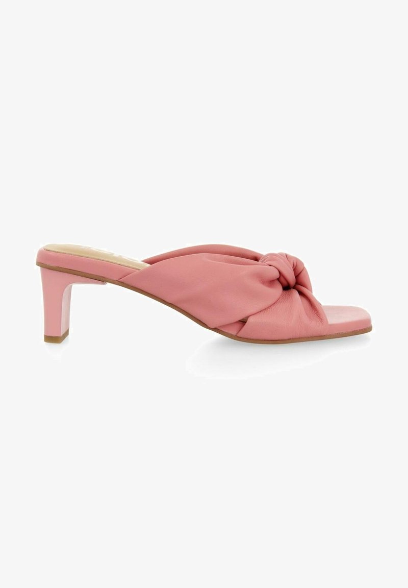 Sandale mule à bout ouvert rose avec dessus en cuir noué et petit talon bloc sur fond blanc.