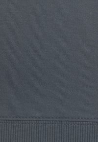 Tela de punto acanalado azul marino con una textura suave, que presenta un patrón de acanalado horizontal. El borde inferior tiene un acanalado más grueso para un ajuste ceñido.