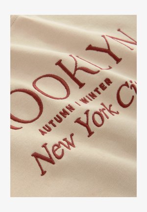 Bežna tkanina s bordo vezom: "BROOKLYN JESEN | ZIMA New York City." Glatka tekstura s blagim sjajem.