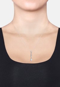 Silberne Anhängerkette mit einem linearen Design, das fünf klare Steine umfasst und in einem tropfenförmigen Stein endet, der an einer zarten Kette hängt.