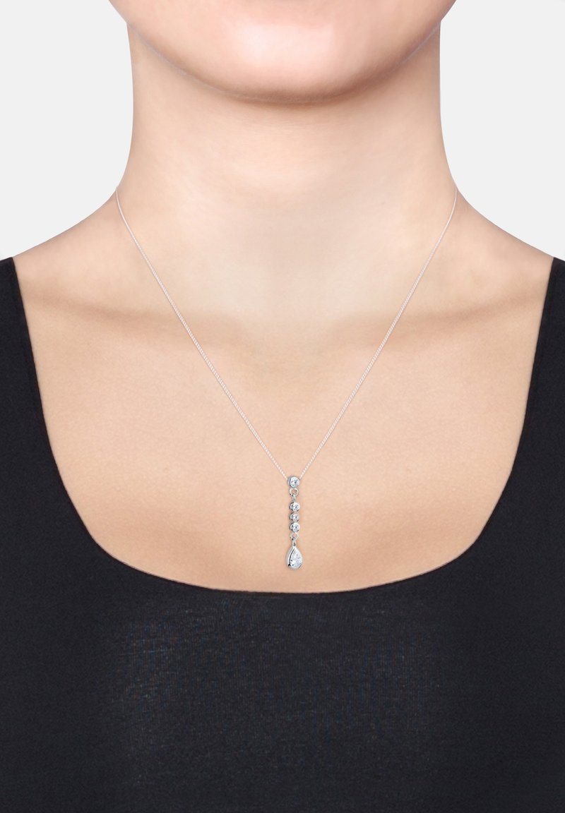 Silberne Anhängerkette mit einem linearen Design, das fünf klare Steine umfasst und in einem tropfenförmigen Stein endet, der an einer zarten Kette hängt.
