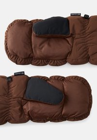 Colete acolchoado castanho com pregas elásticas e um bloco de tecido preto no ombro. Apresenta um fecho de correr e uma etiqueta de logo na lateral. Material macio e isolante.