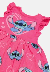 Rosa klänning med kort ärm och volangdetaljer, med en tryck av tecknad karaktär, Stitch och hjärtan på kjolen. Tillverkad av bomull.