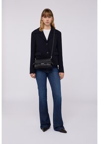 Blazer navy con chiusura a bottoni, tasche frontali; abbinato a jeans blu a palazzo e una borsa a tracolla nera testurizzata, con chiusura magnetica.