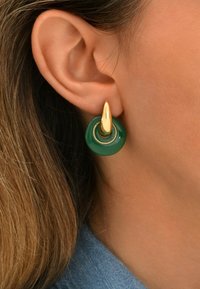 Boucles d'oreilles dorées et vertes avec une base circulaire verte et un accent doré dessus, mettant en valeur un design épuré et une finition polie.
