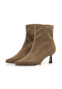 Botas de tobillo de punta afilada hechas de suave ante marrón. Cuentan con un tacón delgado negro y una silueta elegante con detalles de costura mínimos.