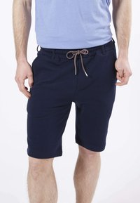 Shorts en coton bleu marine avec une taille élastique, dotés d'un cordon de serrage avec des accents rouges et blancs, et de poches latérales.