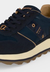 Baskets bleu marine avec accents beige, semelle texturée, lacets bleus et marquage Blauer U.S.A. sur le côté et la languette.