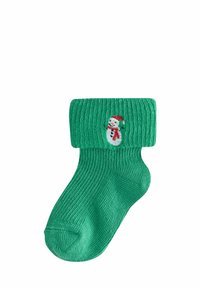 Grüner gestrickter Socken mit gerippter Textur und umgeschlagenem Rand, auf der Außenseite mit einem gestickten Schneemann-Design versehen.