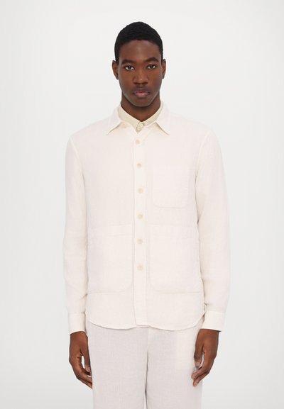 Light beige linen shirt with a collared neckline, button front, single chest pocket, and two front pockets; long sleeves with button cuffs.