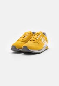 Sneakers gialli in suede con dettagli grigi, superiore testurizzato, lacci bianchi e suola in gomma. Logo stampato sul lato e sulla linguetta.