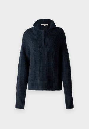 Marineblauer Strickpullover mit hohem Kragen, der strukturierte vertikale Streifen sowie gerippte Bündchen und Saum aufweist. Weiche, grobe Garnzusammensetzung.