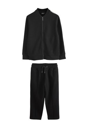 Czarna kurtka na suwak z żebrowanym kołnierzem i mankietami, w zestawie z czarnymi spodnie dresowe ze sznurkiem, oba wykonane z miękkiego materiału.