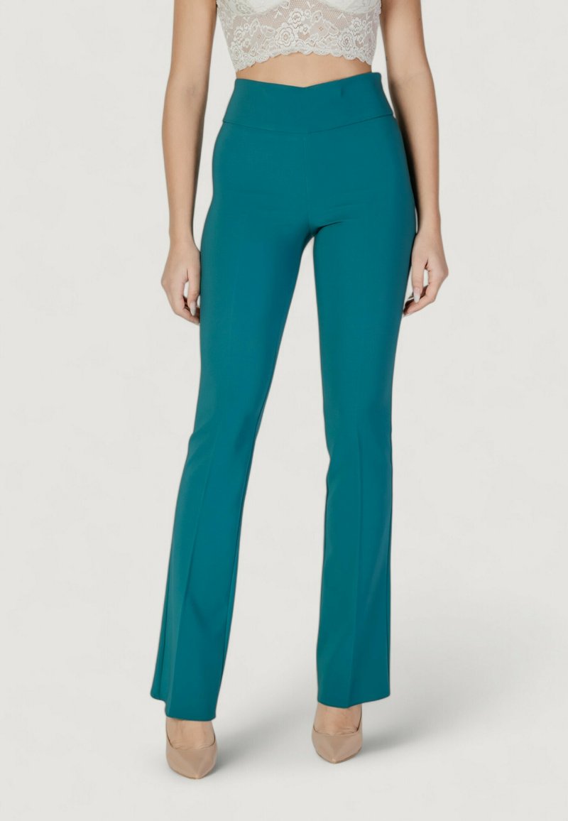 Pantaloni fitted color teal con un design a gamba svasata, realizzati in un tessuto liscio e elastico. Vita alta con rifinitura pulita, abbinati a un top corto in pizzo.