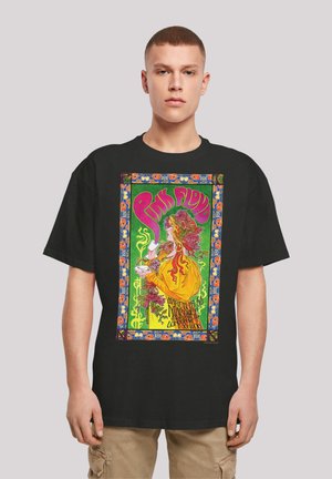Black T-shirt featuring a vibrant graphic of a woman with red hair, holding a drink, framed by colorful floral patterns and "Pink Floyd" text.
