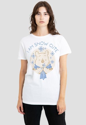 White t-shirt featuring a graphic of a bear wearing a blue scarf with the text "I AM SNOW CUTE" and snowflake accents. Relaxed fit.