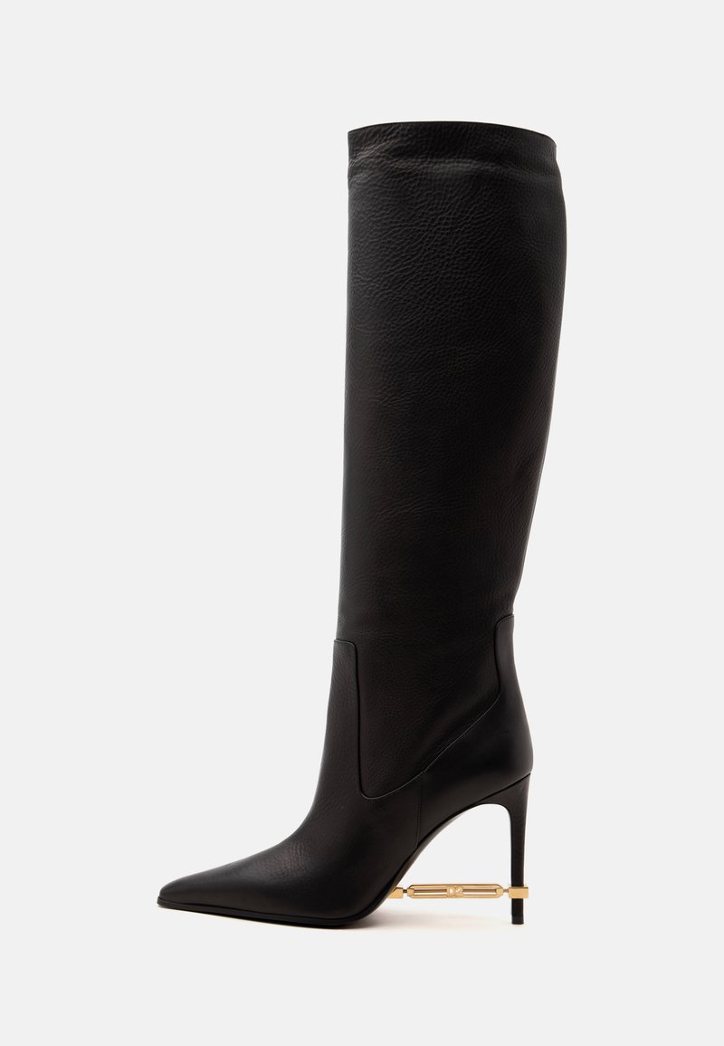Botte haute en cuir noir à bout pointu avec un talon aiguilles fin et un détail décoratif en métal doré près du talon.