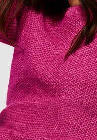 Sweter dzianinowy w kolorze fuksji o teksturowanej, tkanej tkaninie. Posiada okrągły dekolt i długie rękawy, prezentując jasny, jednolity kolor.