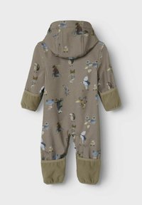 Barnens beige jumpsuit med lekfulla djurtryck och en huva. Kontrastfärgade gröna fleece-muddar och fötter. Mjuk tyg med strukturerade mönster.