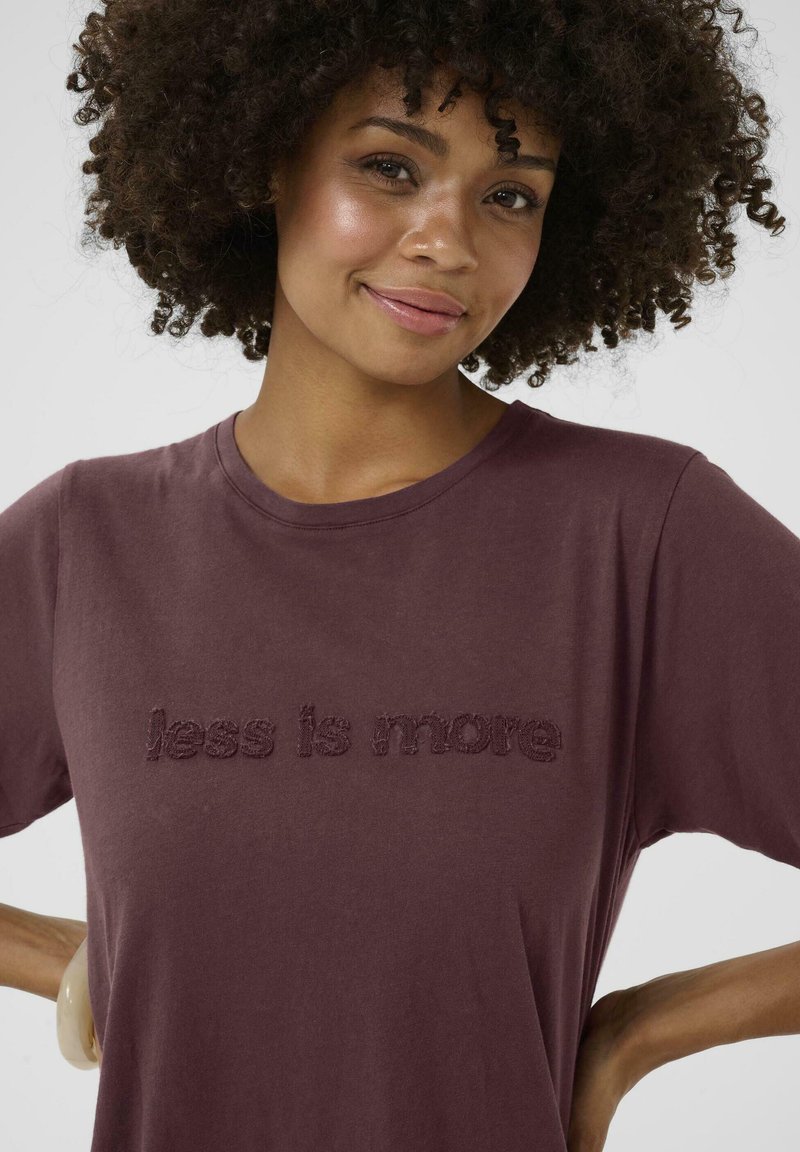 Bordeaux katoenen t-shirt met de verhoogde tekst "less is more" in een bijpassende kleur, met een klassieke ronde halslijn en korte mouwen.