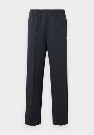 Pantalon de sport noir avec taille élastique, coupe droite et plis subtils. Confectionné en tissu doux et texturé pour un confort optimal.