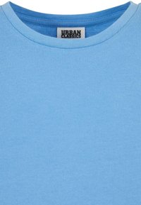T-shirt en coton bleu clair avec un col ras du cou côtelé et une étiquette portant l'inscription "URBAN CLASSICS". Le tissu a une texture lisse.