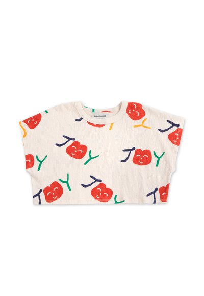 Bomuld crop top med korte, brede ærmer. Har en cremefarvet bund og farverige tryk af røde æbler med ansigtstræk, grønne stilke og legende tekst.