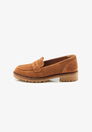 Braune Wildleder-Slipper mit runder Zehenpartie, dekorativem Riemen, Nietenakzenten und einer Gummisohle mit strukturiertem Muster.