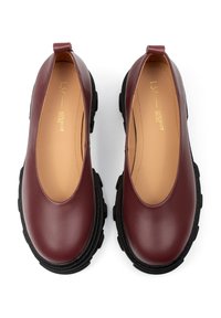 Burgundy leather shoes with a sleek design, rounded toe, and contrasting black rubber sole. Includes a pull tab at the heel for easy wear.