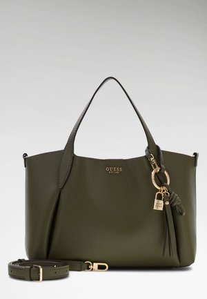Sac cabas Guess olive foncé avec poignées courtes, ornement en métal doré et bandoulière amovible, sur fond uni.