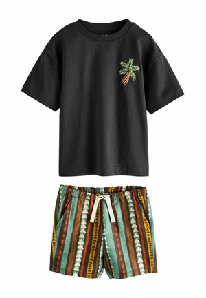 Schwarzes kurzärmliges Hemd mit kleinem grünem Palmenmuster, kombiniert mit Shorts mit Kordelzug und vertikalen, mehrfarbigen geometrischen Streifen.