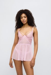 Ροζ, διαφανές babydoll εσώρουχο με υφή από πουά, λεπτομέρειες από δαντέλα, ρυθμιζόμενους ιμάντες και εφαρμοστό μπούστο που ανοίγει σε φαρδύ φόρεμα.
