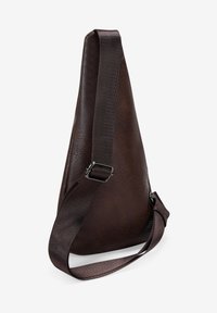 Bolso cruzado de cuero marrón con superficie texturizada, forma triangular, correa de tela ajustable y herrajes de metal.