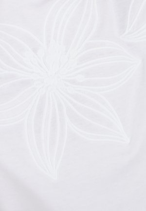 Tessuto bianco con un motivo di ricamo floreale in rilievo caratterizzato da petali lunghi e delicati e accenti circolari al centro.