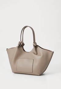 Beige skinnveske med doble knyttede håndtak, en ytterlomme og en glatt tekstur. Har et romslig indre og en myk, avrundet form.