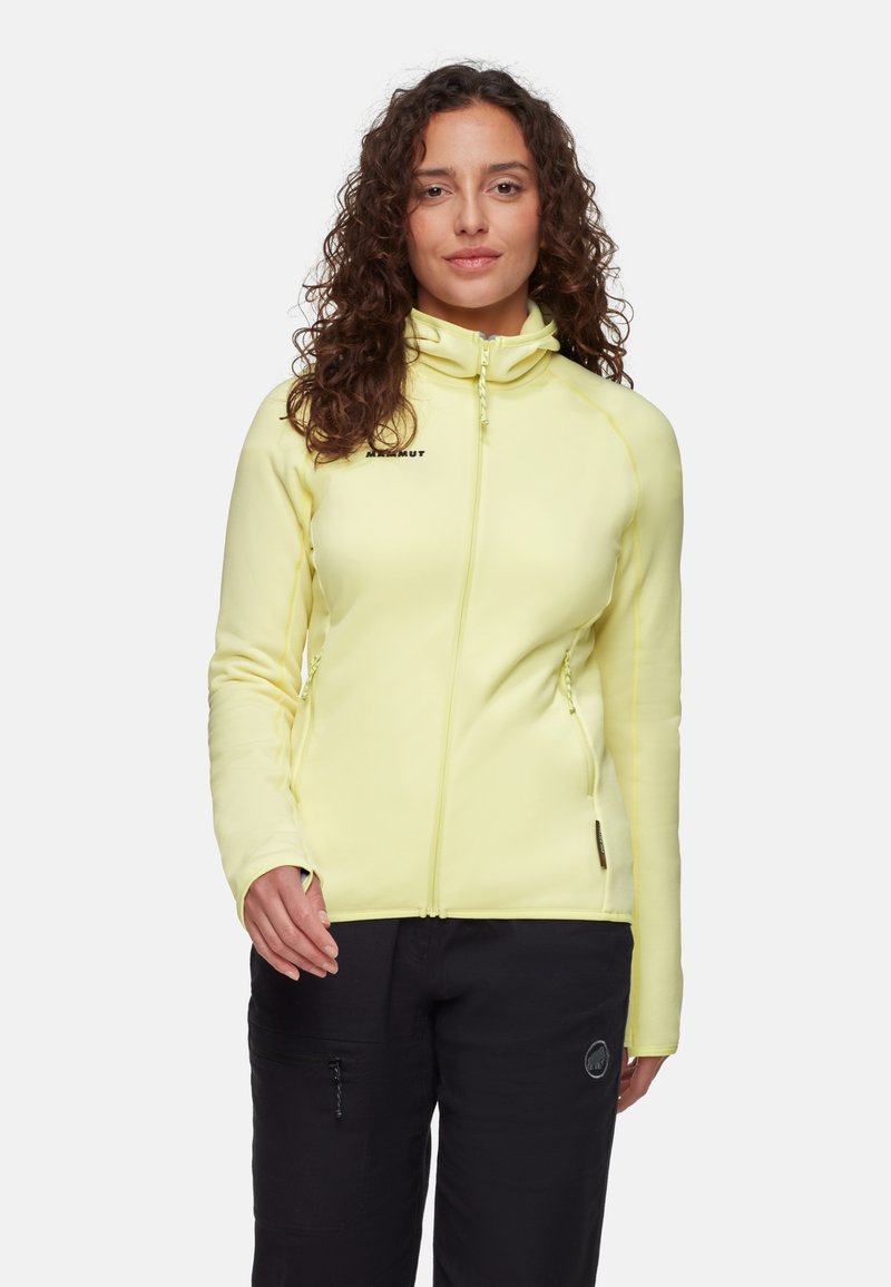 Giacca zip-up gialla chiara realizzata in tessuto elastico. Presenta un design aderente, colletto alto e due tasche laterali con zip.