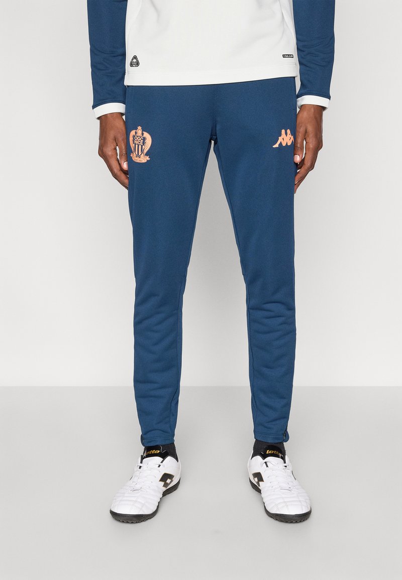 Μπλε ναυτικού χρώματος αθλητικό παντελόνι με πορτοκαλί λογότυπο στο αριστερό μηρό, με εφαρμοστή γραμμή και ελαστική μέση, κατασκευασμένο από λείο ύφασμα.