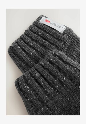 Šedé pletené rukavice s žebrovanou texturou, zdobené jemnými skvrnami a štítkem 3M Thinsulate. Materiál vypadá teplý a silný.