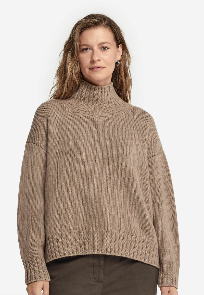 Beige Rollkragenpullover mit grober Rippstruktur, lockerer Passform, überschnittenen Schultern und breiten Bündchen. Verfügt über einen hohen Kragen und einem geraden Saum.