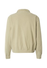 Chaqueta de pana beige con mangas largas, puños con botones, dobladillo elástico y cuello clásico, vista desde atrás.