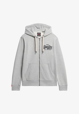 Sudadera de cremallera gris claro con un bolsillo frontal, capucha con cordones y marca bordada. Tejido suave con puños y dobladillo acanalados.