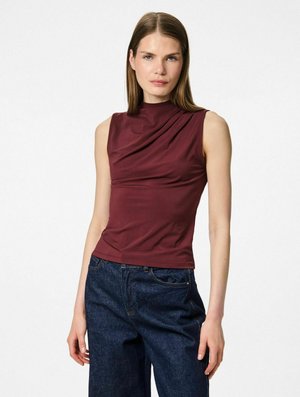 Top sans manches bordeaux avec un col drapé et une texture lisse, associé à un jean à jambes larges bleu foncé. Design simple et ajusté.