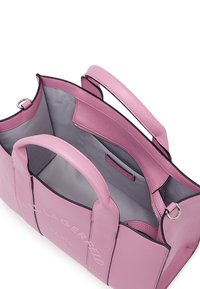 Rózsaszín táska dupla fogantyúval, szürke belső béléssel, belső cipzáras zsebbel és a "Karl Lagerfeld Paris" felirattal a elején. 