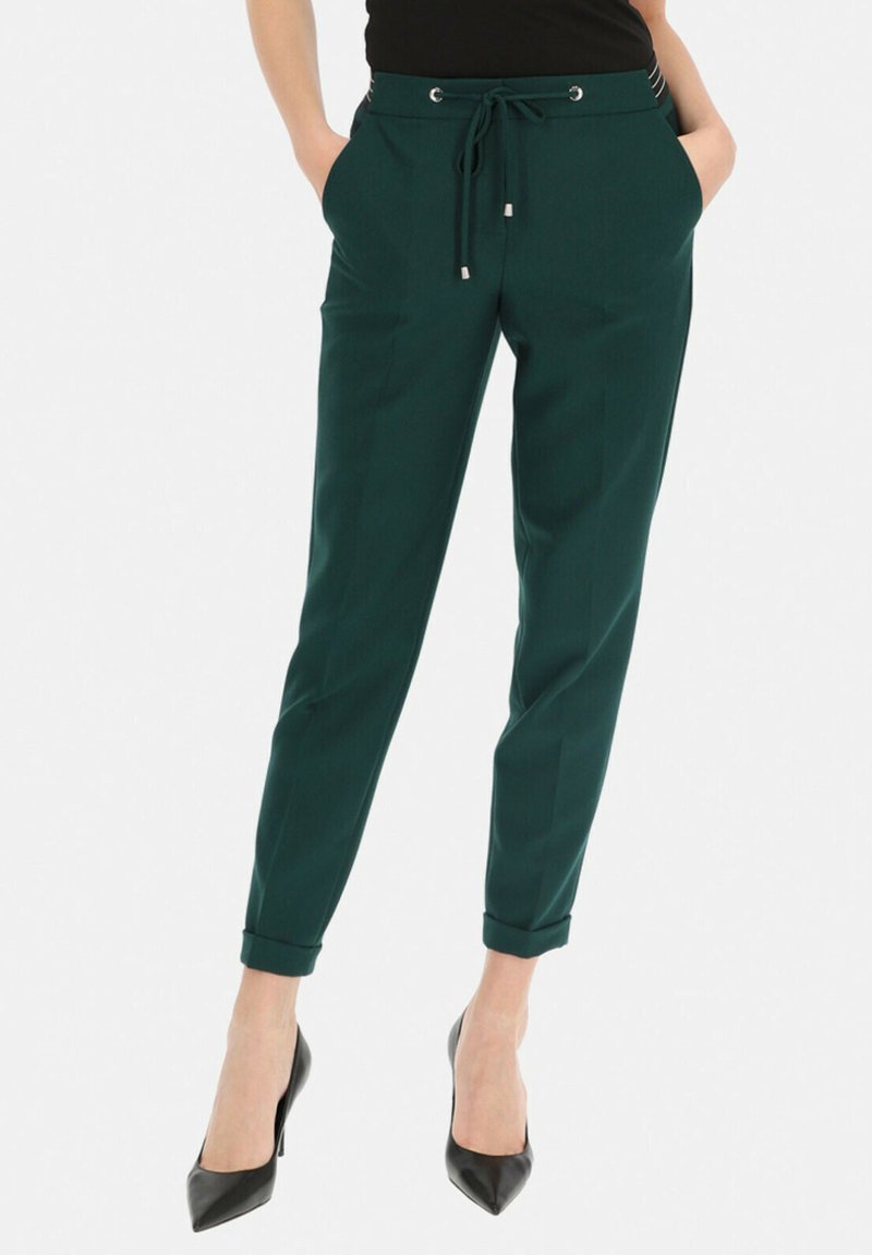 Ciemnozielone spodnie w tapered z elastycznym pasem na sznurki, bocznymi kieszeniami i podwiniętymi mankietami. Gładka faktura z akcentami w srebrnym kolorze.