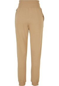 Kaki joggere laget av myk stoff, med en ribbet høy midje, elastiske manchetter og sidelommer for ekstra funksjonalitet.