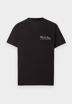 Schwarzes T-Shirt mit kurzen Ärmeln und Rundhalsausschnitt, mit weißem Aufdruck "Work In Progress" und kleinem Text darunter auf der linken Brustseite.